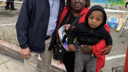 Asm. Muratsuchi with attendee holding child