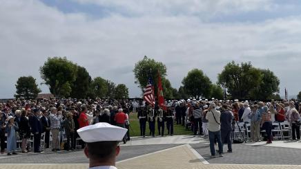 Marines carrying flags, with large audience on either side
