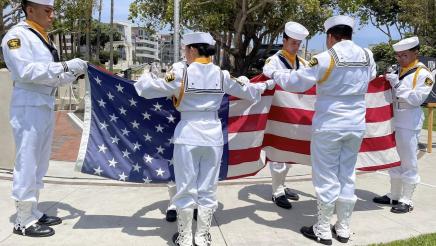Naval cadets handling large American flag
