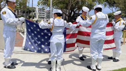 Naval cadets handling large American flag