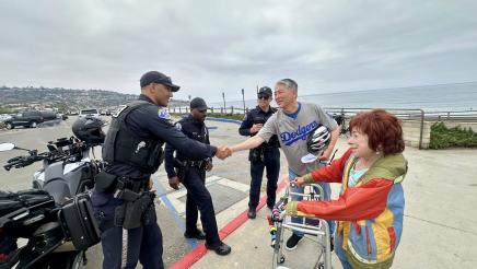 Asm. Muratsuchi shaking hands with police officers, while Rabbi Katz looks on