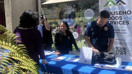 Staffers at resource table assisting constituent