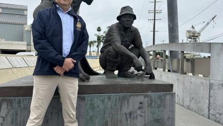 Asm. Muratsuchi standing in front of memorial
